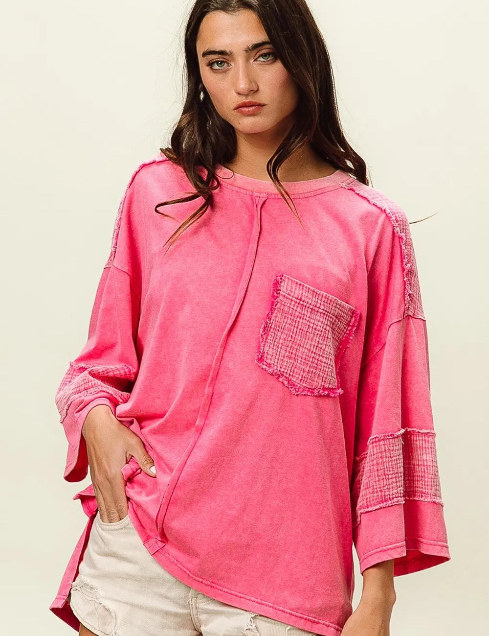 Neon pink oversized sweatshirt with frayed edges and pocket detail