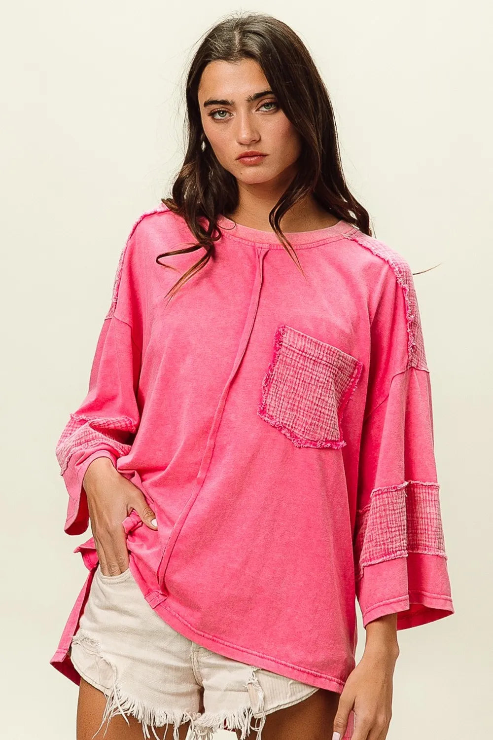 Neon pink oversized sweatshirt with frayed edges and pocket detail