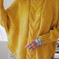 Cozy mustard-yellow cable-knit turtleneck sweater with wide sleeves