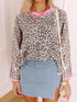 Leopard print cropped hoodie with pink trim over denim mini skirt