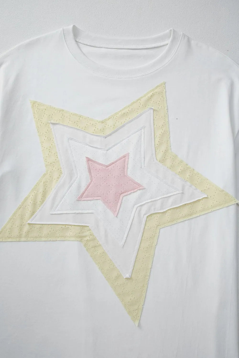 White drop shoulder tee with layered star applique in yellow and pink