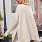 Beige knit V-neck poncho with ribbed cuffs, hem, and loose silhouette
