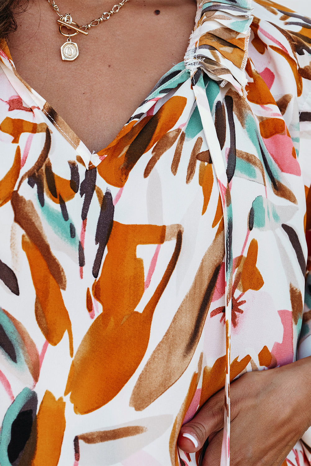 Woman in yellow abstract print drawstring frilled V-neck 3/4 sleeve blouse