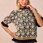BiBi Textured Rose Knit Top in black and cream floral print with ruffled sleeves and hem