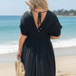 Black flowing Daverri Fashions maxi dress with deep V-neck, back tie, and side slit
