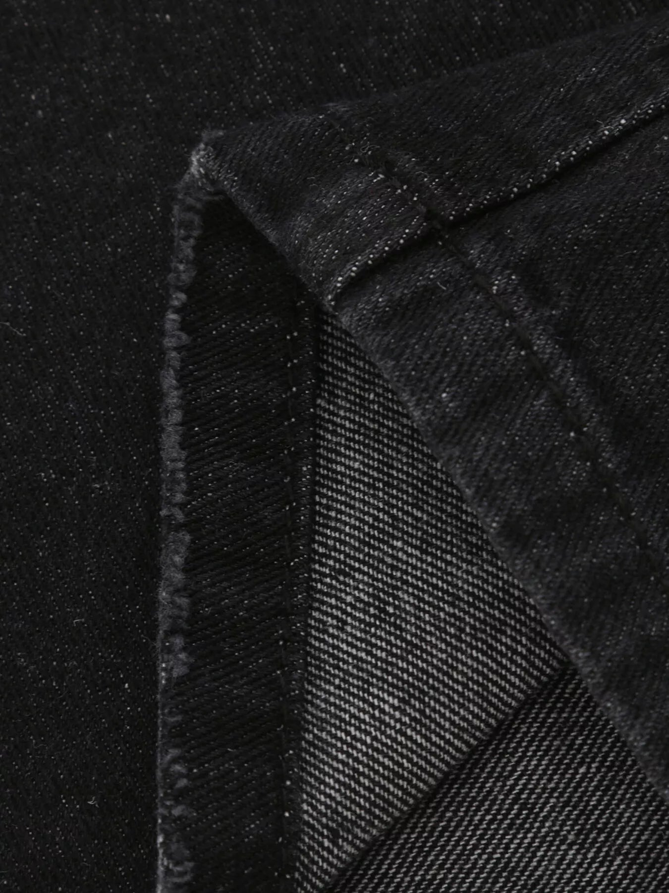Distressed loose fit jeans in black denim with worn texture and seam stitching