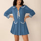 Blue pleated mini dress with Peter Pan collar, tie front, and sailor trim