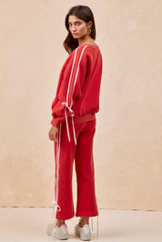 Red drawstring track pants with white stripes and pockets