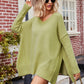 Oversized soft olive green V-neck slit exposed seam sweater with ribbed cuffs and hem