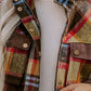 Multicolored plaid women’s long sleeve pocketed flannel vest with brown suede accents and brass buttons
