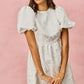 White textured mini dress with puff sleeves and gathered waist