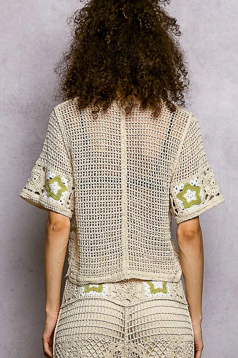 Beige crochet cardigan with green star motifs on sleeves and waistband