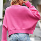 Pink cropped knit sweater with round neck, drop shoulders, and ribbed cuffs