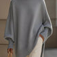 Light gray oversized knit poncho with batwing sleeves and ribbed cuffs