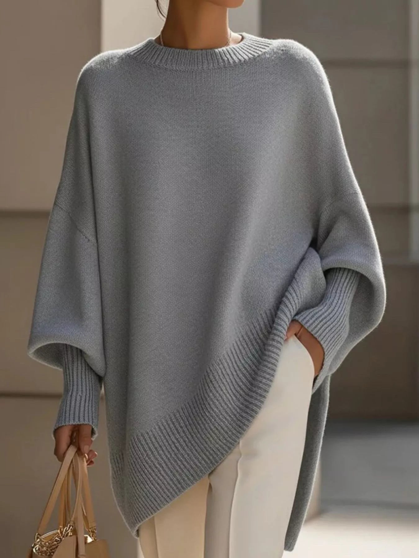 Light gray oversized knit poncho with batwing sleeves and ribbed cuffs