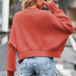 Soft coral cropped sweater with round neck, drop shoulders, and ribbed cuffs
