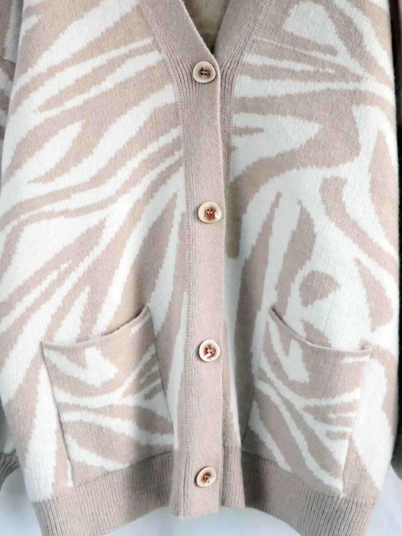 Beige and white zebra print button-up cardigan with gold buttons