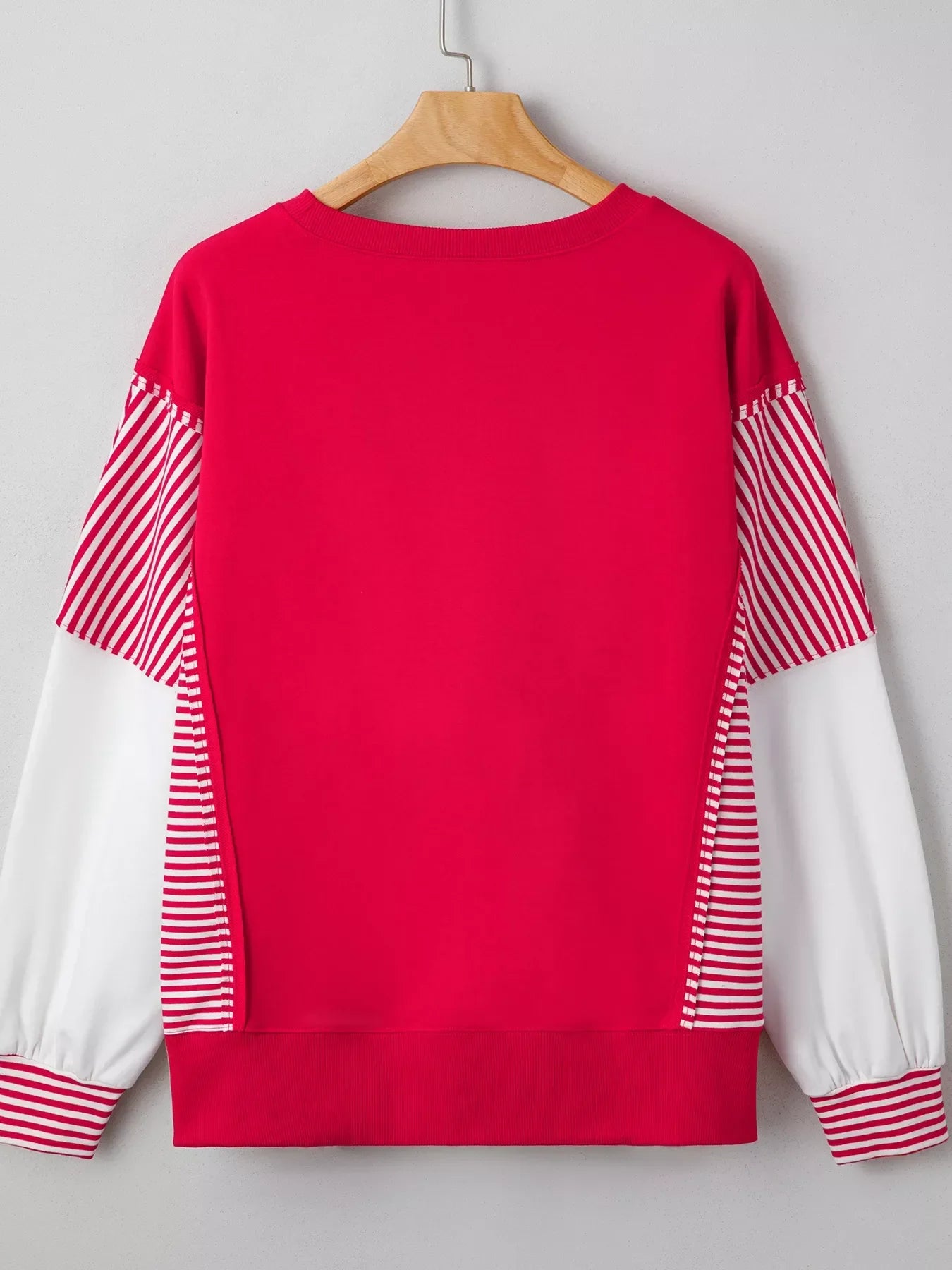 Red and white striped sweater with balloon patchwork sleeves on wooden hanger