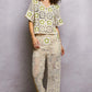 Woman in cream and sage crochet cardigan with star contrast and wide-leg pants