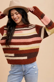 Multicolored striped patchwork sweater with jeans and tan hat