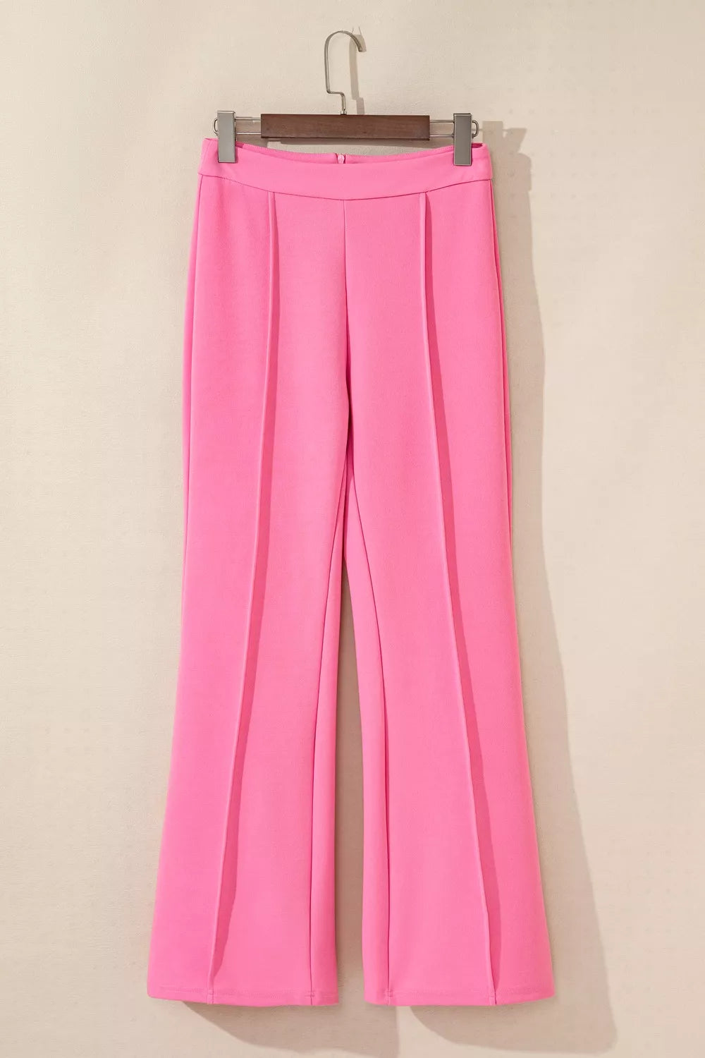 Bright pink high-waisted bootcut pants with pleats and smooth fabric