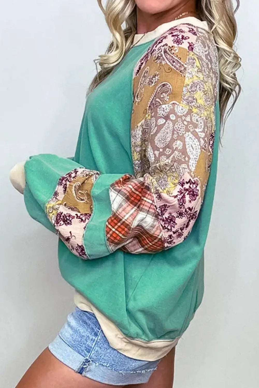 Plus size teal and beige patchwork raglan sleeve sweatshirt with paisley, floral, and plaid panels