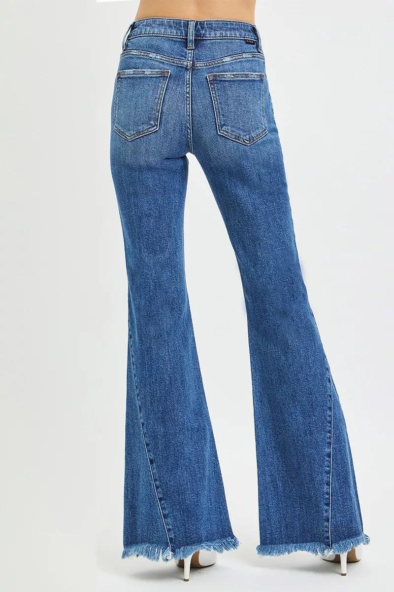 Back view of RISEN mid-rise flare jeans in blue denim with frayed hems