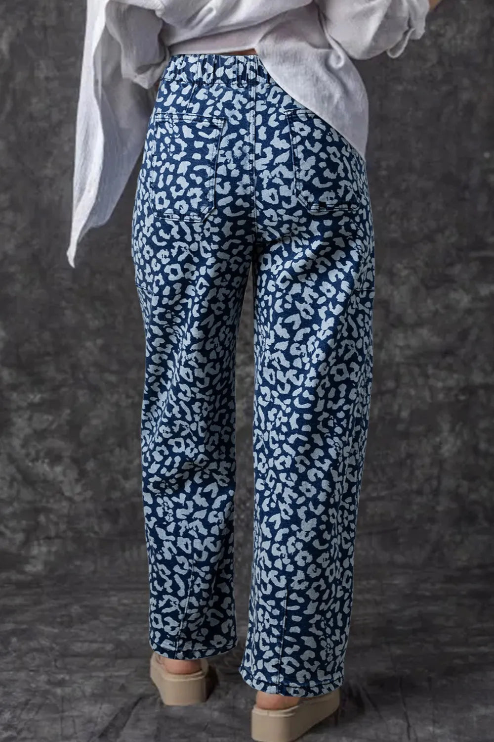 Leopard print wide leg jeans with high waist on blue background