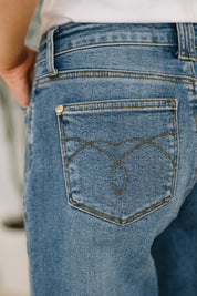 Blue denim Bella high-waist jeans with gold button and subtle pocket pattern