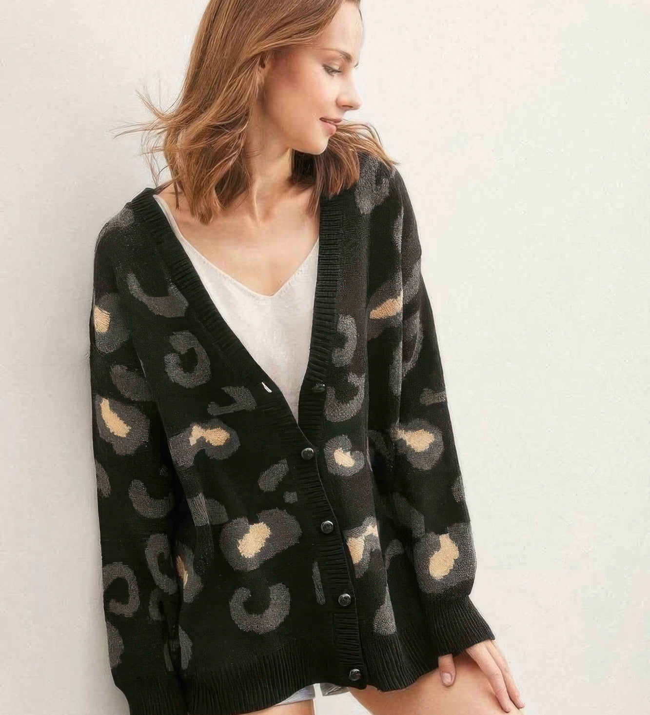 A woman wearing a black leopard print cardigan