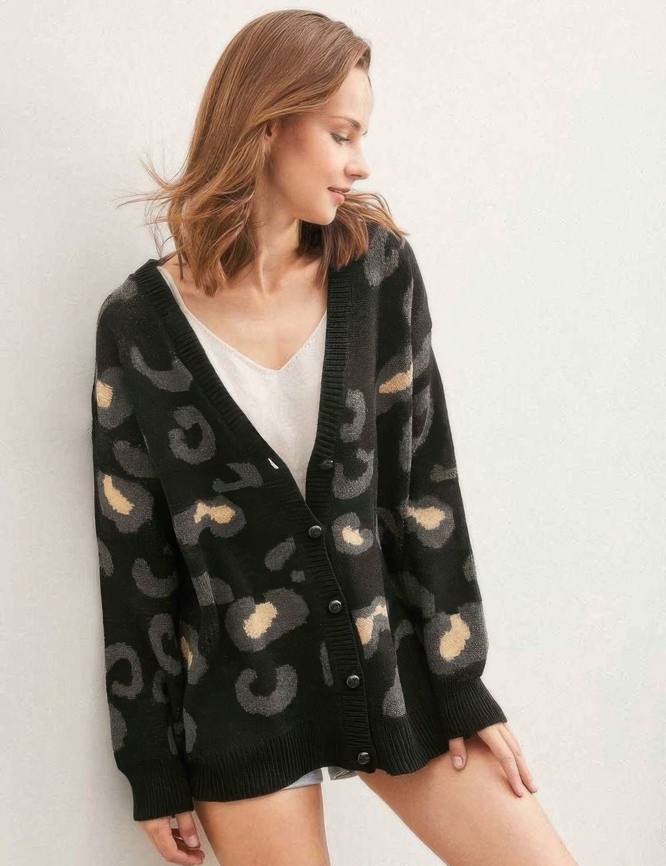A woman wearing a black leopard print cardigan