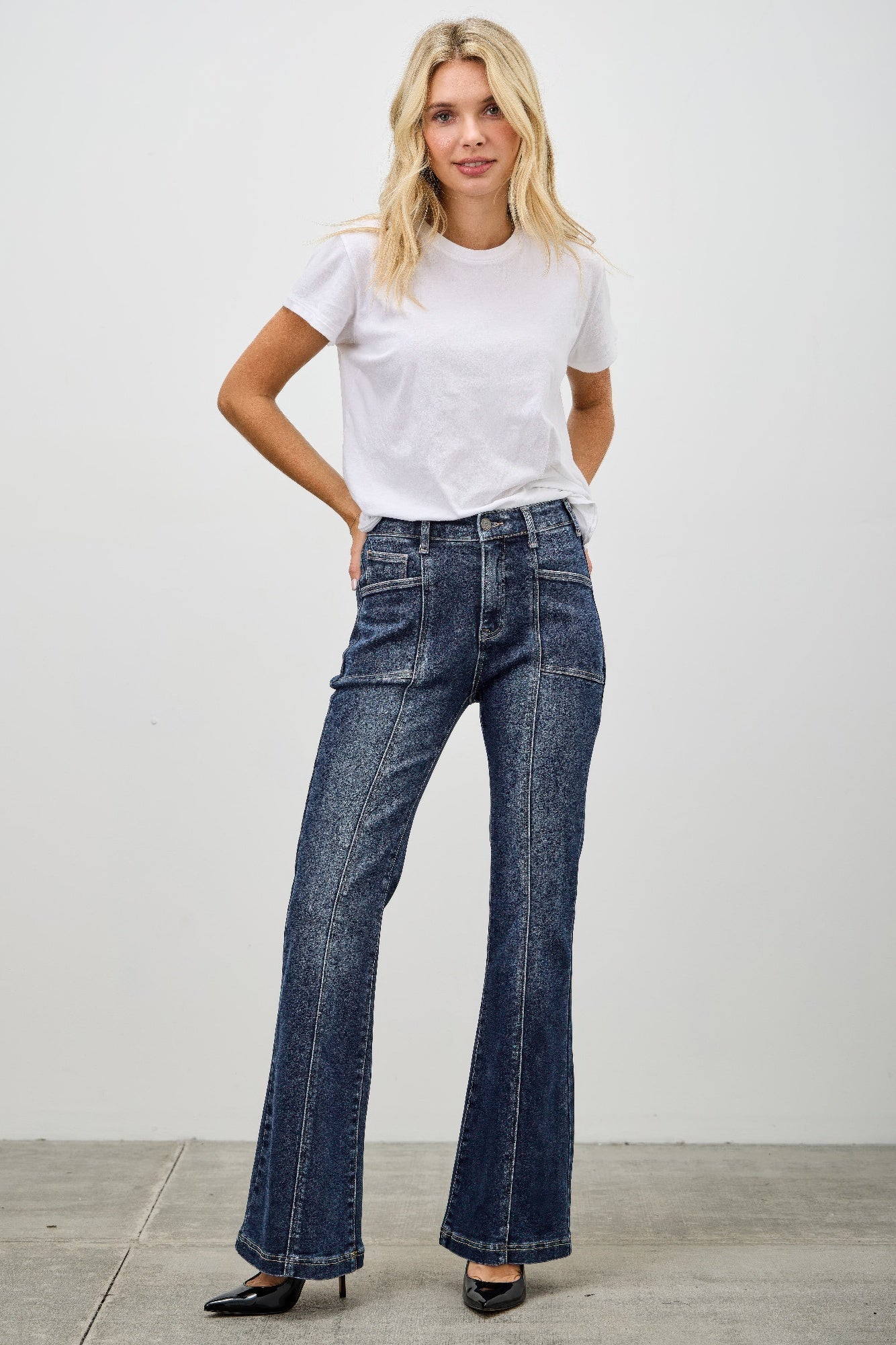 High-waisted dark wash denim flare pants with textured finish and seam detail