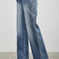 High-waisted blue denim wide-leg jeans with faded wash and pintuck details