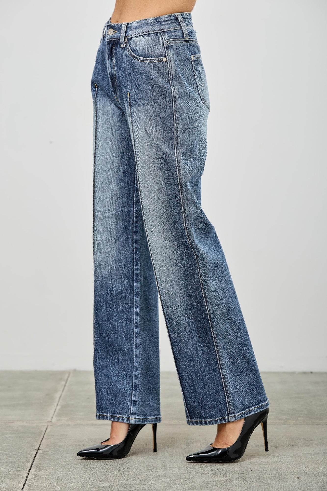 High-waisted blue denim wide-leg jeans with faded wash and pintuck details