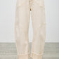 High-rise beige wide-leg denim pants with rolled cuffs and stitched paneling