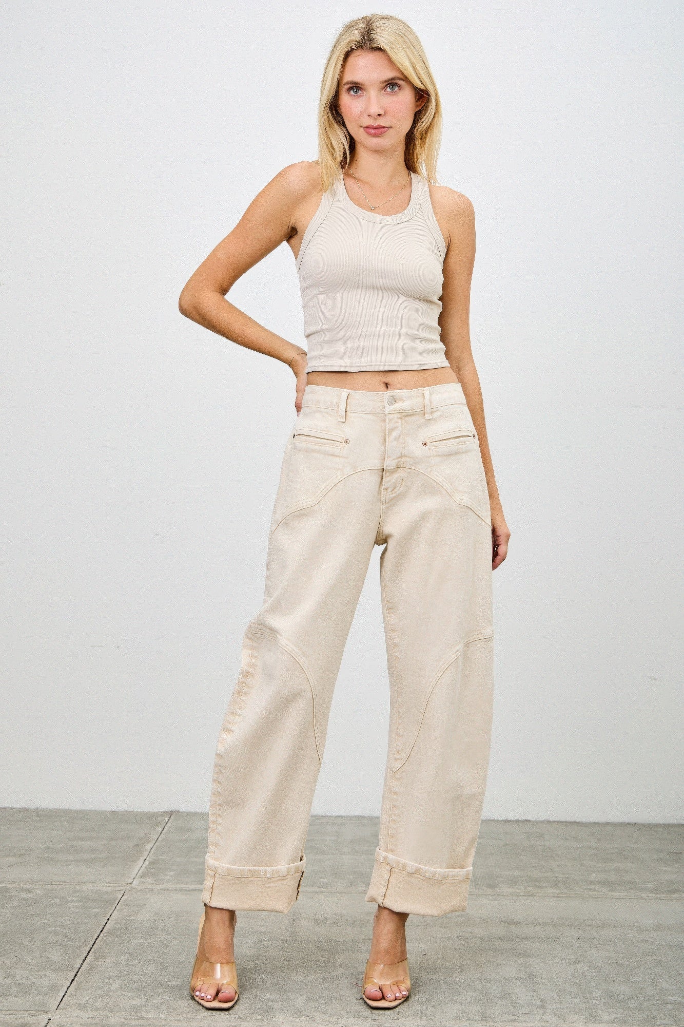 Beige high-rise wide-leg jeans with rolled cuffs and subtle stitching