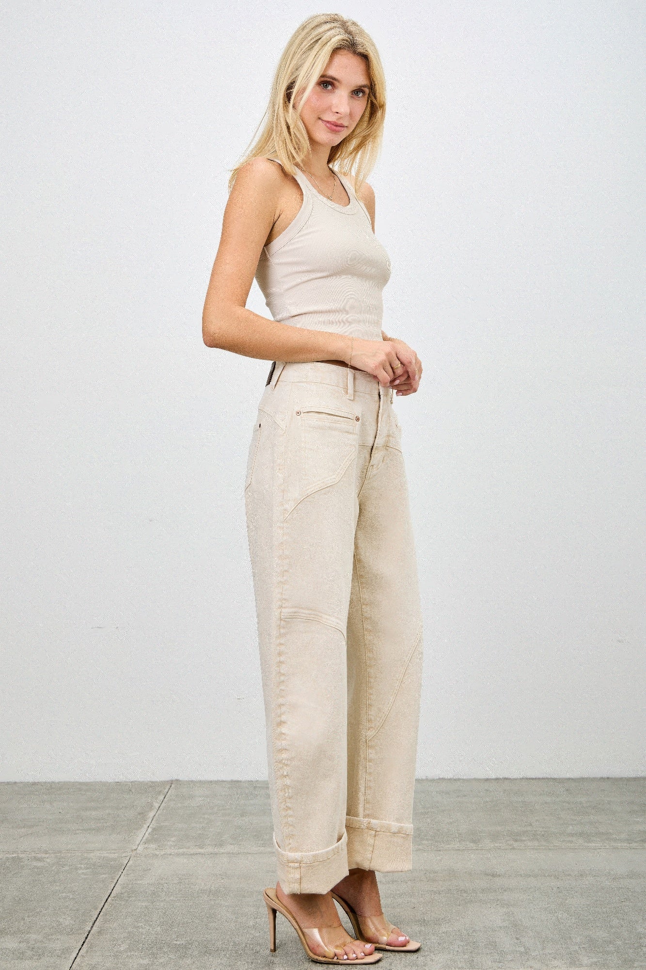 High-rise beige wide-leg denim pants with rolled cuffs and patch pockets