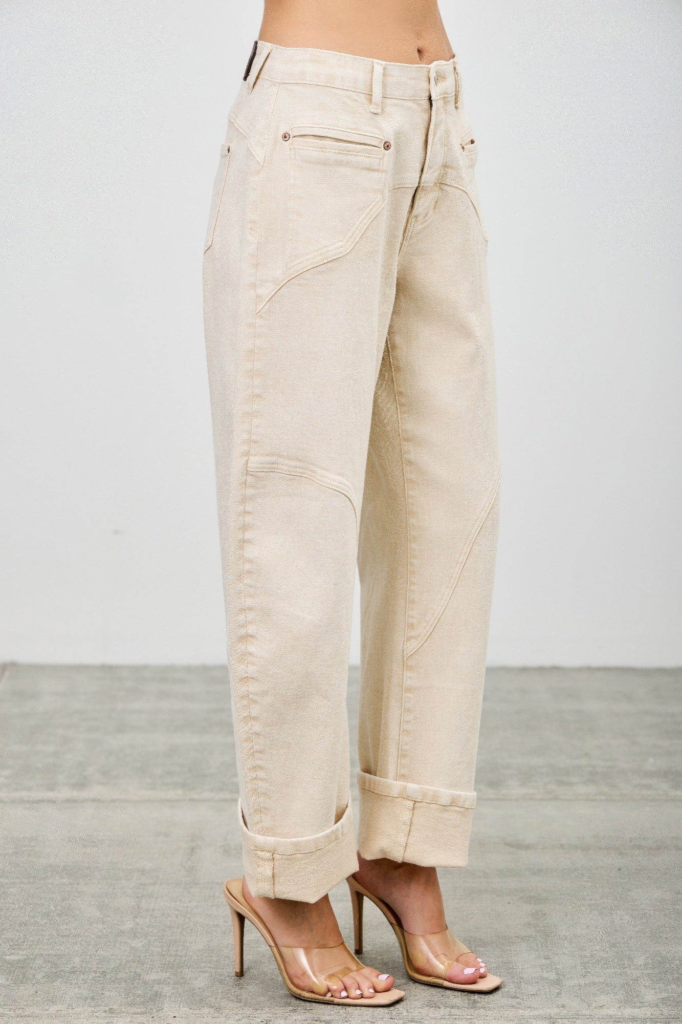 High-rise beige wide-leg denim pants with rolled cuffs and patchwork