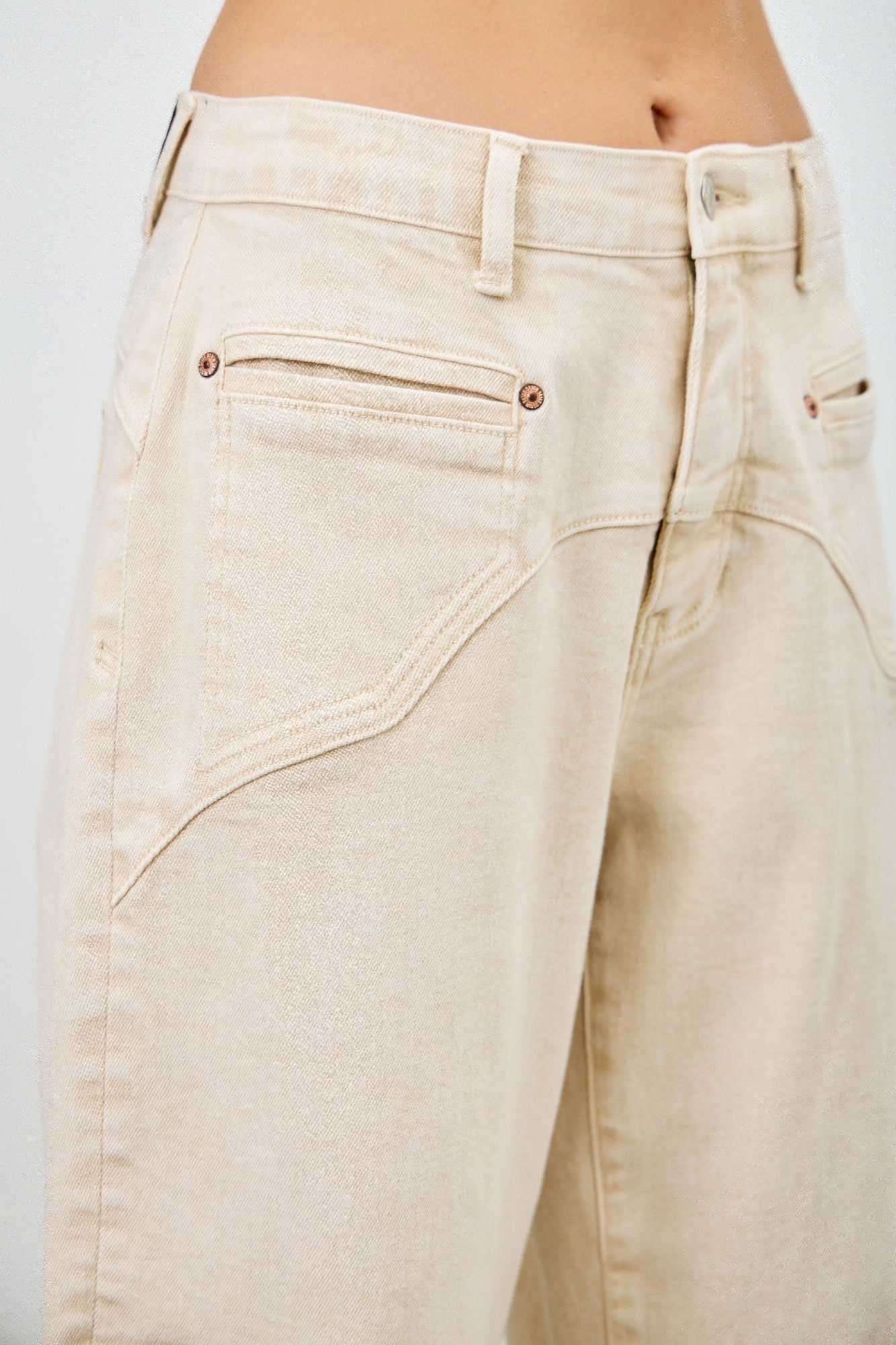 High-rise beige denim jeans with relaxed fit and subtle stitching