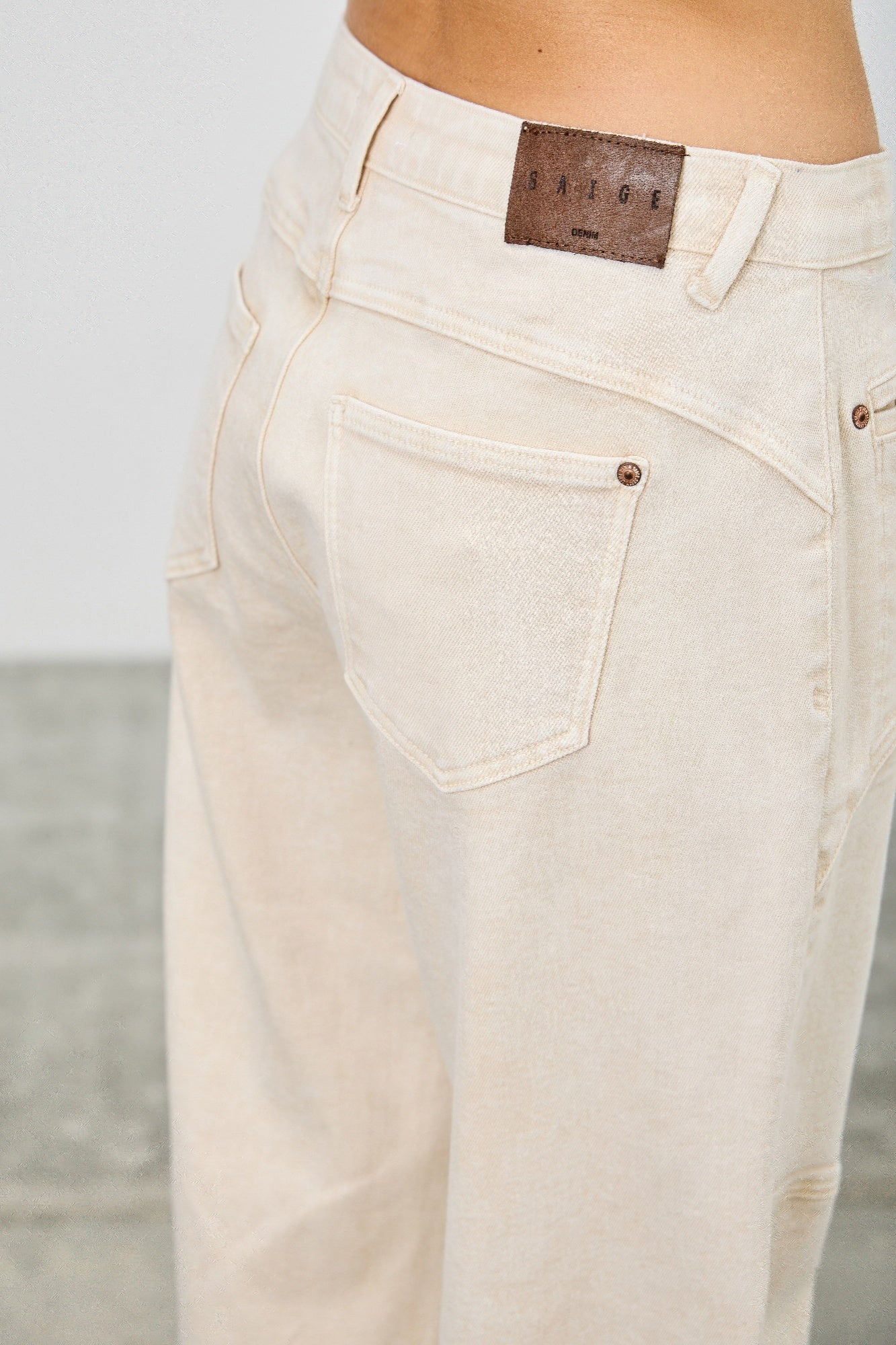 Cream-colored high-rise denim jeans with brown leather patch, Western Barrel style