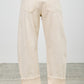 High-rise beige wide-leg denim pants with rolled cuffs and brown leather patch