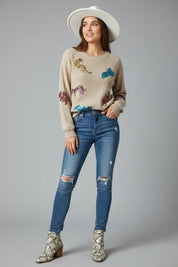 Beige dinosaur sequin dropped shoulder sweatshirt with embroidered details and distressed jeans