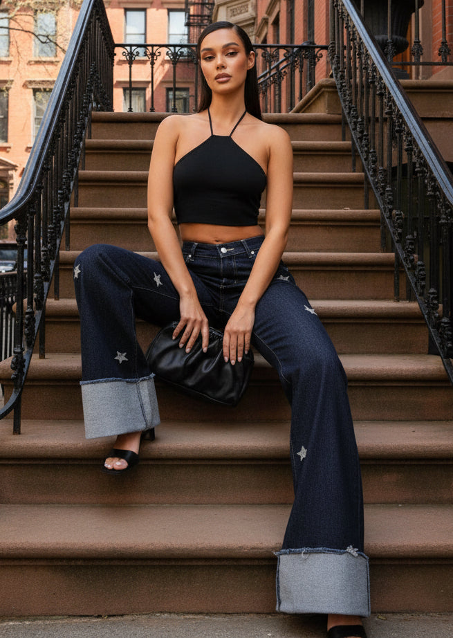 Black leather clutch with textured sheen on diamond stars jeans
