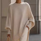 Cream-colored oversized knit poncho with batwing sleeves and slanted hem
