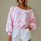 Woman wearing a pink and white floral cropped sweatshirt with white shorts 