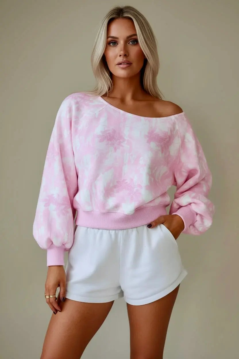 Woman wearing a pink and white floral cropped sweatshirt with white shorts 