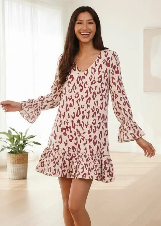 Woman in beige leopard print mini dress with ruffle cuffs