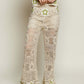 Cream-colored openwork crochet flare pants with green star motifs