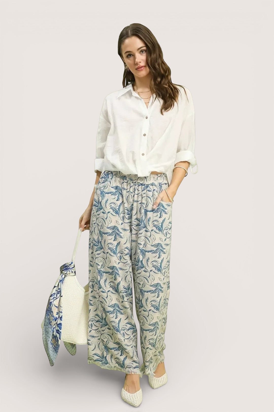 Woman in Umgee Linen Printed Wide Leg Raw Hem Pants with blue leaf pattern