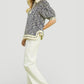 Woman in Umgee Geometric Leaf Print Popover Top with ivory trousers